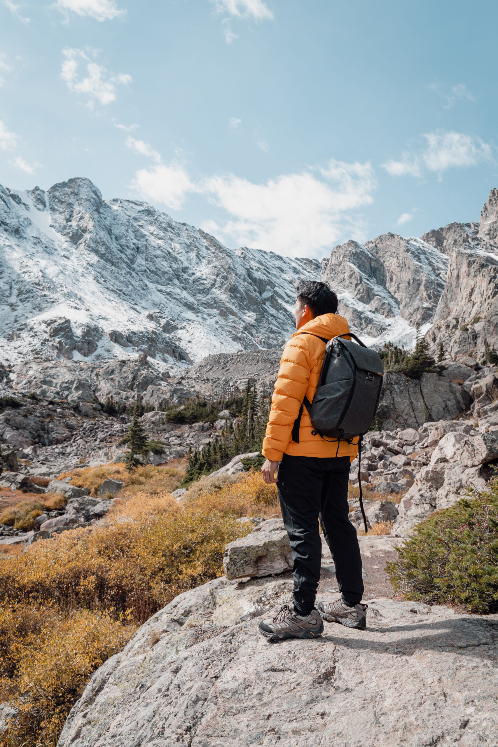 A person wearing yellow looking off to the left where there is a large mountain